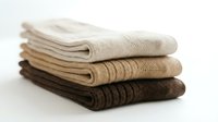 Stack of three folded knitted socks in neutral earth tones, beige, tan, and brown, neatly arranged on a white background.