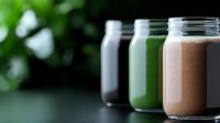 Colorful healthy smoothies in glass jars arranged in row against dark background with green bokeh. Fresh protein drinks and detox beverages for wellness lifestyle.