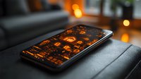 Modern smartphone displaying glowing orange app icons on dark leather surface with ambient bokeh lights in background, creating moody atmospheric composition.