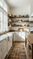 Modern farmhouse kitchen with white cabinetry, open shelving displaying brass and ceramic bowls, marble countertops, and natural light from large windows. Interior design and home decor inspiration.