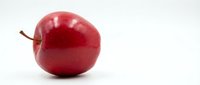 Fresh red apple with stem isolated on white background, suitable for food, nutrition, health and wellness design projects.