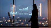 Silhouette of woman analyzing financial data on holographic display in modern office with city skyline at dusk, suitable for business, finance, and technology concepts.