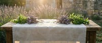 Fresh lavender bunches and herbs arranged on rustic wooden table with linen runner in sunny garden setting for natural home decor and aromatherapy.