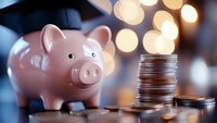 Pink piggy bank with stacked coins on wooden surface with warm bokeh lights background for savings and financial planning concepts.