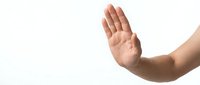 Human hand making stop gesture with open palm raised against white background isolated for design and communication concepts.