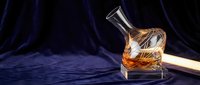 Premium whiskey in elegant crystal decanter with warm amber liquid, luxury spirits collection on dark wooden surface for sophisticated drinking experience.