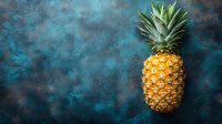Fresh ripe pineapple on dark moody blue textured background with copy space. Minimalist food photography concept for menu design and advertising.