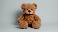 Fluffy brown teddy bear sitting against light background, soft plush toy with friendly expression and classic design for childhood, nursery and gift concepts.