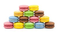 Colorful French macarons pyramid stack isolated on white background. Sweet dessert cookies in rainbow colors for bakery menu and confectionery design.