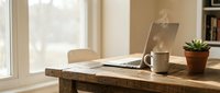 Cozy home office workspace with laptop, coffee mug and succulent plant on rustic wooden desk by bright window for remote work and productivity.