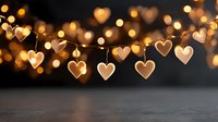 Warm golden heart-shaped string lights creating romantic bokeh effect on dark wooden surface for Valentine's Day celebrations and love themes.