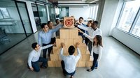 Diverse business team building a cardboard box pyramid topped with a target symbol, representing teamwork, goals, and corporate success.