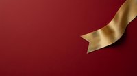 Gold ribbon flowing across deep red background, perfect for holiday cards, gift wrapping designs, and festive promotional materials.