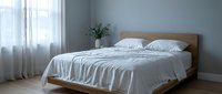 Modern minimalist bedroom interior with wooden bed frame, white bedding, and natural light from large window creating serene sleeping space.
