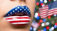 Woman with patriotic flag-themed lip art featuring stars and stripes design for Independence Day celebration with festive background.