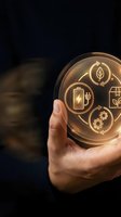 Hand holding glowing orb with sustainable energy icons including battery, leaf, solar panel and gears on dark background for renewable energy concepts.