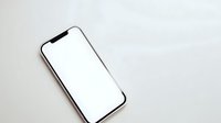 Modern smartphone with blank white screen mockup on neutral background for app presentation and digital design projects.