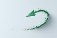 Green paper arrow with glitter trail effect on white background, creating dynamic curved motion path. Minimalist design concept for business growth and progress.