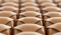 Abstract geometric pattern of repeating curved metallic copper shapes creating dimensional surface with light and shadow effect. Modern minimalist background.