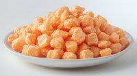 Orange cheese puffs snack food in white bowl isolated on white background ready for packaging design and marketing materials.
