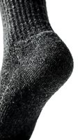 Close-up macro shot of a dark gray knitted sock heel on white background, showcasing textile texture and fabric detail for fashion or retail use.