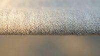 Close-up of neutral linen fabric texture with soft natural lighting, showcasing woven material surface for textile, interior design, and fashion projects.