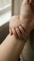 Therapist using a metal scraping tool on a patient's knee during myofascial release or IASTM soft tissue therapy session.