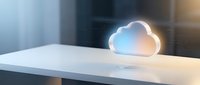 Glowing cloud computing icon on modern white desk in office environment representing digital technology and data storage solutions for business applications.