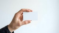 Male hand holding blank white business card against neutral background, suitable for branding, corporate identity, and marketing presentations.