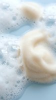 Natural sea sponge with soap bubbles in foamy water for skincare and spa treatments. Organic bath accessories for wellness and relaxation routines.