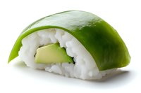 Fresh avocado nigiri sushi with rice on white background, traditional Japanese cuisine close-up macro photography showing texture and detail.