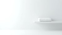 Minimalist white towel roll on floating shelf against neutral wall, isolated on clean background for spa, bathroom, and wellness design projects.