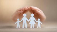Hands protectively covering paper cutout family figures symbolizing family protection, care, and support in insurance, social services, and family therapy.