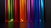 Vibrant rainbow colored silk fabric drapes with dramatic lighting creating colorful reflections on dark surface, flowing vertical lines in red, green, orange, purple and blue.