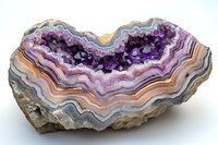 Purple amethyst geode crystal with layered banded agate formation showing natural striped patterns in violet, pink, and gray tones on white background.