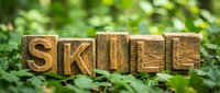 Wooden skill blocks arranged on green moss and foliage, representing education, learning development, and professional growth for training and development concepts.
