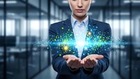 Professional businessman in suit holding glowing digital particles and light effects in modern office environment representing innovation and technology solutions.