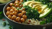 Nutritious plant-based bowl with roasted chickpeas, quinoa, fresh avocado slices, and kale for healthy meal prep or vegan dining.