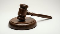 Wooden judge gavel and sound block on neutral background for legal proceedings, courtroom decisions, and justice system concepts.