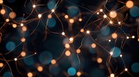 Glowing string lights creating magical atmosphere against dark blue bokeh background, perfect for festive holiday decorations.