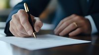 Close up view of business person signing document with luxury pen, cropped shot focused on male hands in formal suit writing on white paper at desk.