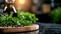 Fresh green basil leaves and peppercorns on wooden cutting board against dark background with warm lighting and selective focus for culinary design.