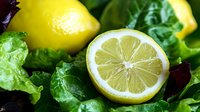 Fresh lemon slices with mint leaves on dark background for healthy drinks, cooking recipes, natural ingredients and organic food preparation.