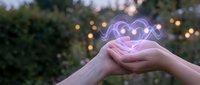 Hands holding glowing purple heart symbol with bokeh lights background representing love, care, charity and emotional connection in outdoor setting.