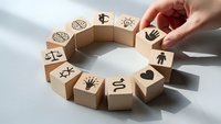 Hand placing wooden blocks with business icons in circular formation representing teamwork and corporate strategy development.