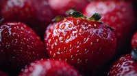 Fresh ripe strawberries with water drops in macro photography showing detailed texture and vibrant red color against dark background for food design.
