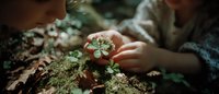 Young woman gently touching small white wildflowers growing from mossy forest floor in natural woodland setting with soft sunlight filtering through trees.