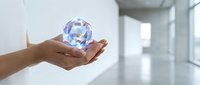 Hands holding glowing holographic crystal sphere in modern office space with digital light effects and futuristic technology concept for innovation presentations.