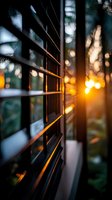 Sunlight streaming through window blinds creating dramatic shadows and warm bokeh effect at sunset, with soft focus and atmospheric mood for interior design.