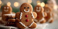 Festive gingerbread cookies with white icing details and red buttons arranged on wooden surface with warm bokeh lights creating cozy holiday atmosphere.
